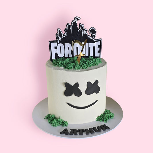 Fortnite birthday cake with Marshmello face design, green icing detail, and personalised topper for gamer-themed celebration