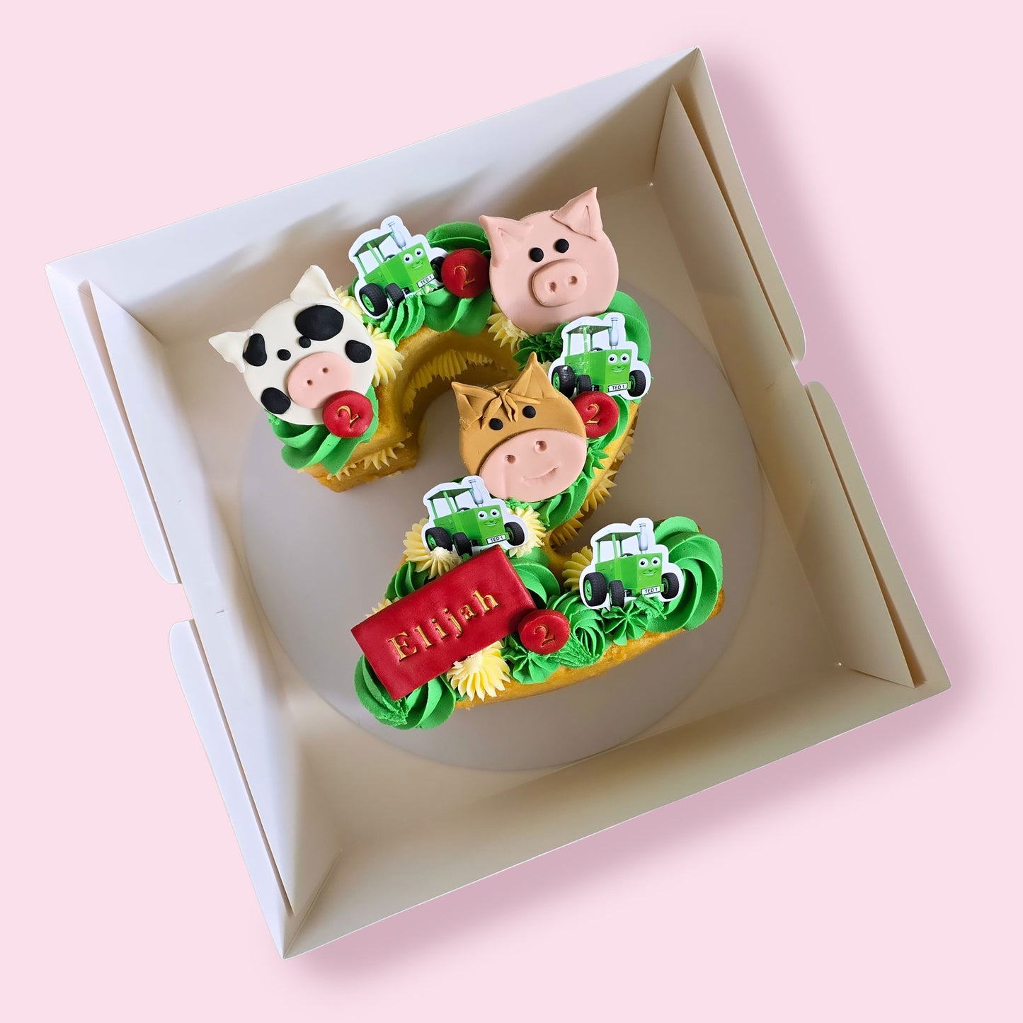 Farm-themed number 2 birthday cake with animal toppers, tractors, tractor Ted, green and yellow buttercream