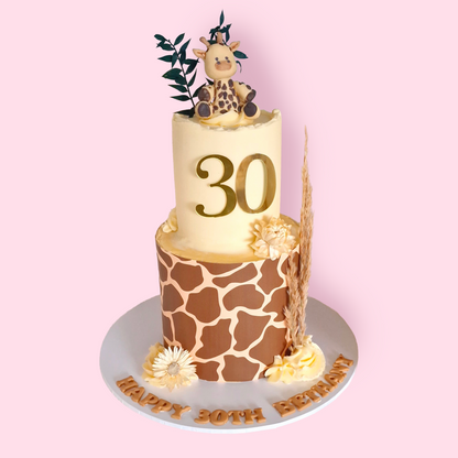 Two-tier giraffe print birthday cake with fondant giraffe topper, dried florals, and gold number 30 for Bethany’s celebration
