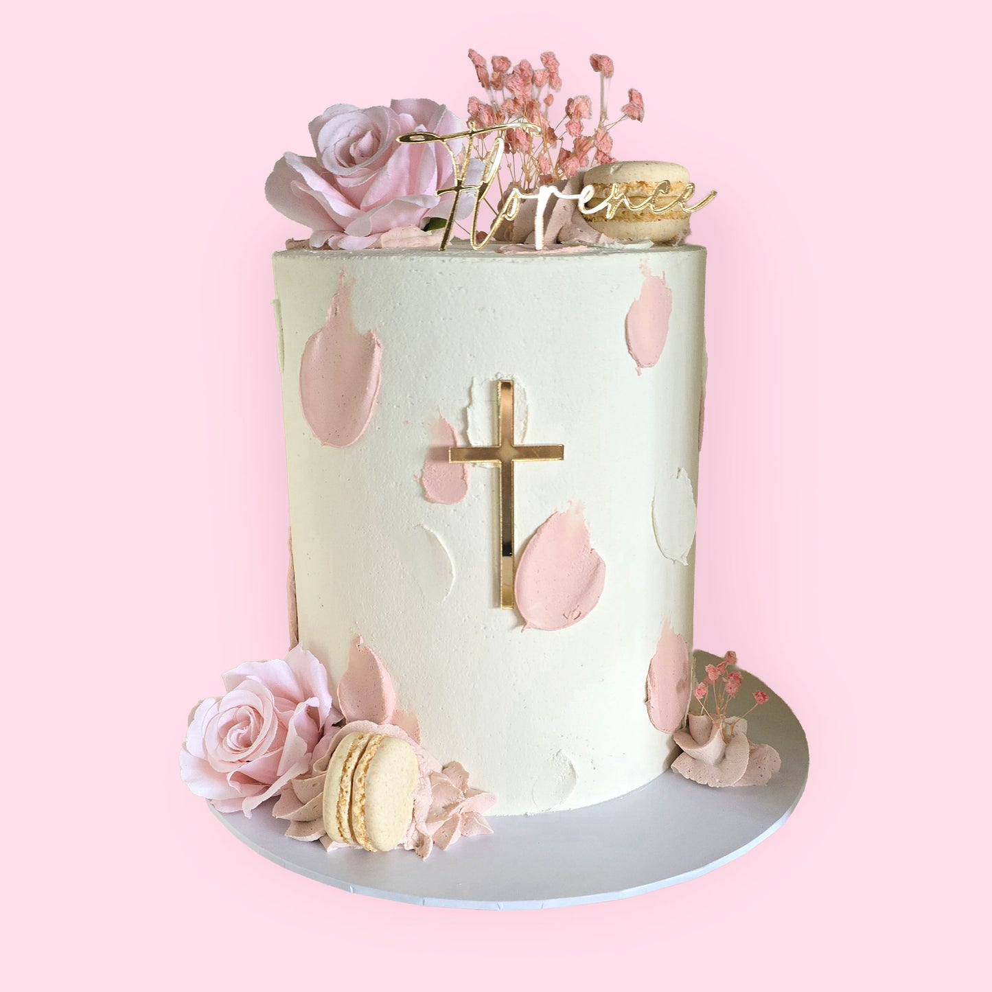 Elegant pink and white christening cake with gold cross, floral accents, and personalised name Florence