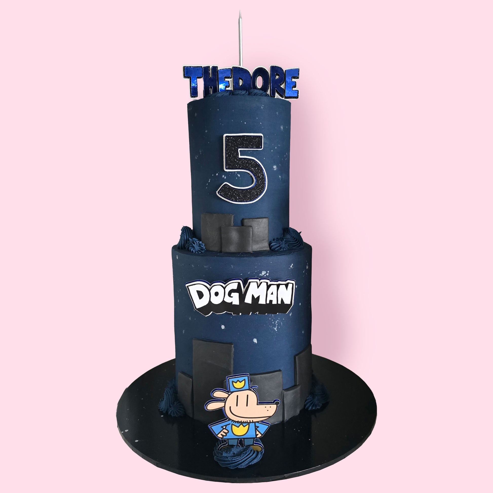 Custom Dog Man-themed two-tier birthday cake with black and navy blue fondant, cartoon topper,